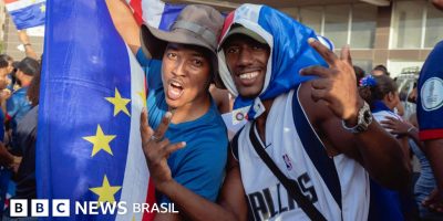 Legenda da foto, A bandeira de Cabo Verde, adotada em 1992, exibe listras azuis, brancas e vermel...