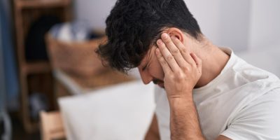 Homem apoia uma das mãos na orelha