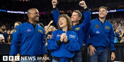 Legenda da foto, A equipe do Artemis 2 comemora com os fãs enquanto assiste à final do basquete...