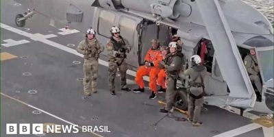 Legenda da foto, Os astronautas Christina Koch e Victor Glover foram fotografados sentados no hel...